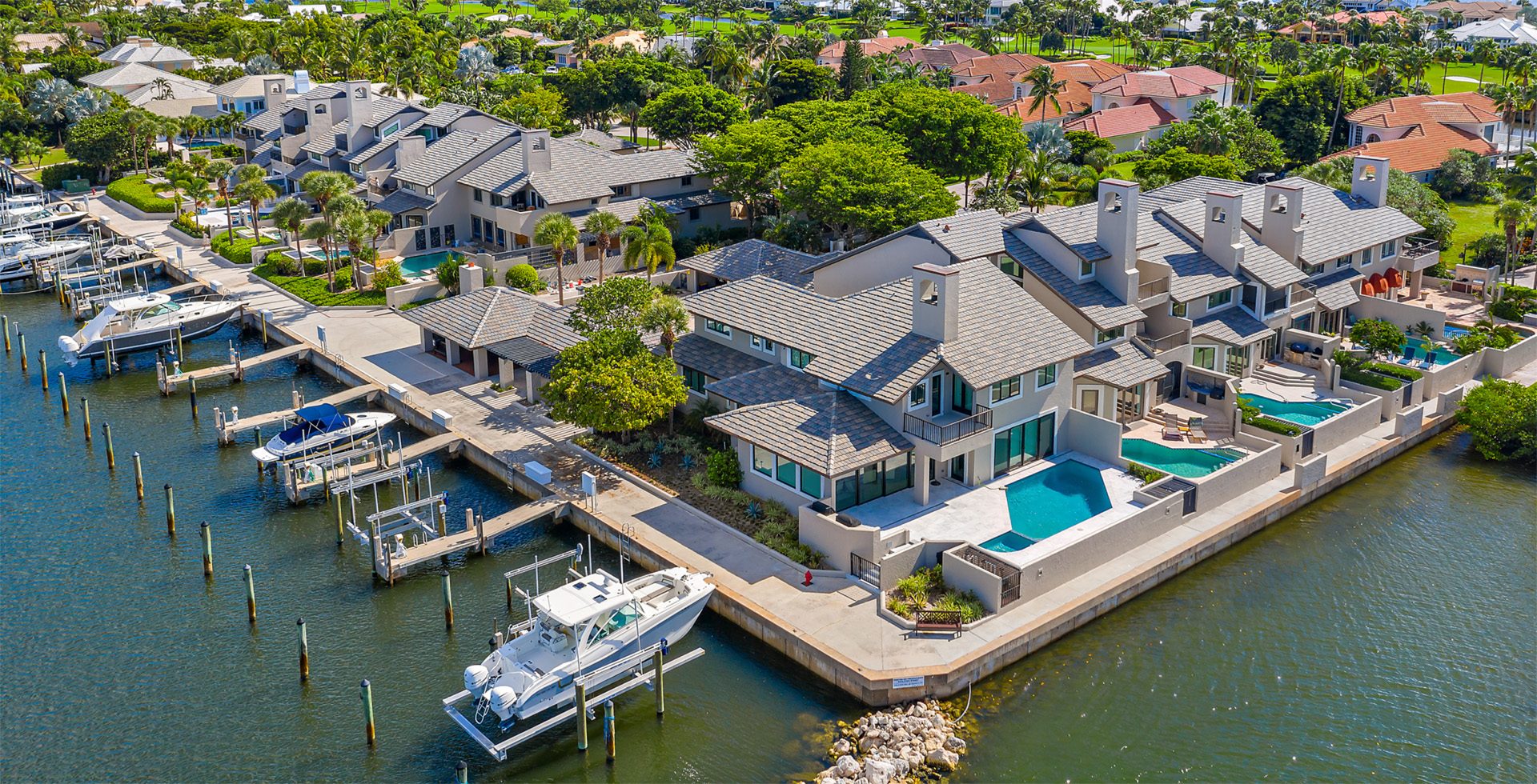 Drone aerial of waterfront South Florida homes with new shingle and tile roofs
